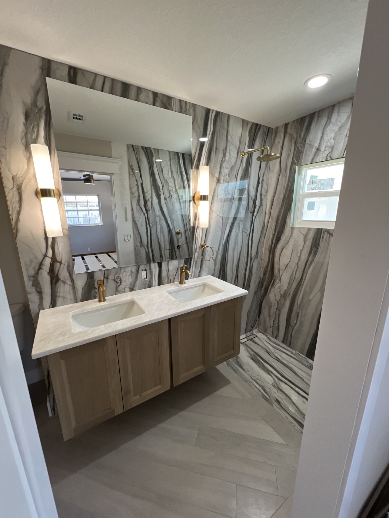 Finished dramatic marble bathroom with floating vanity by All Surface Experts Co.